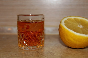 Alcoholic drink poured into a transparent glass in combination with lemon