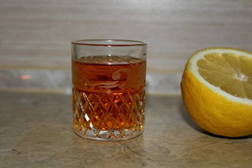 Alcoholic drink poured into a transparent glass in combination with lemon