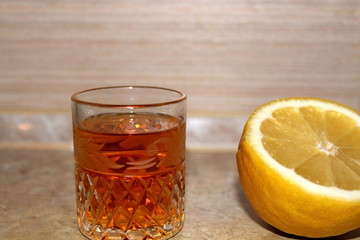 Alcoholic drink poured into a transparent glass in combination with lemon