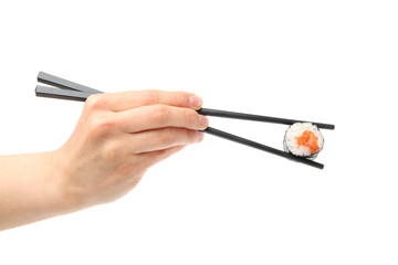 Female hand with chopsticks holds sushi roll, isolated on white background