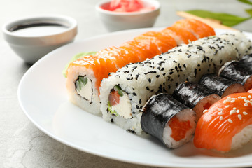 Plate with sushi rolls on gray background. Japanese food