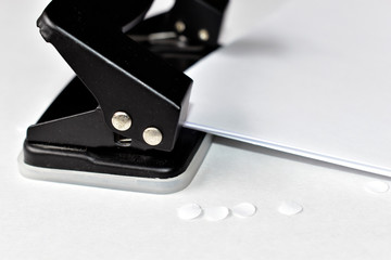 A clerical hole punch in the business with a hand a dollar and paper