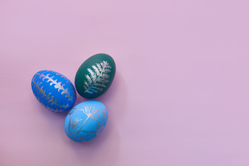 painted easter eggs on pink background top view. flat lay with copy space