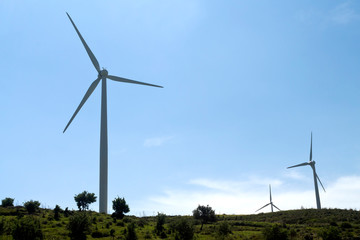 Fototapeta na wymiar Wind turbine towers in front of blue sky