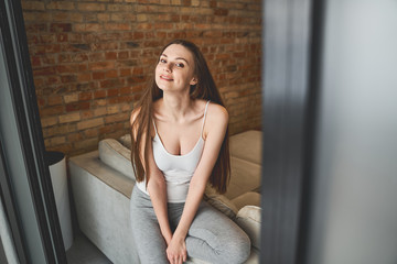 Fototapeta premium Girl whiling away her time on the sofa