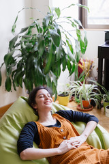 Portrait of cheerful woman resting at home. Stay home concept. Vertical side view of woman relax and laying down during quarantine time of coronavirus. People lifestyle during covid 19 concept.