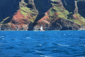 Sailboat Cruise in Blue Pacific Ocean near Napali Coast Cliffs in Kauai Hawaii