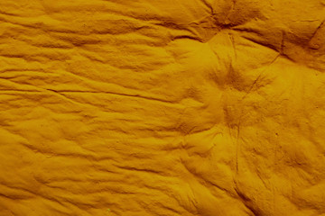 The texture of yellow chewed chewing gum. Background of yellow chewing gum after chewing