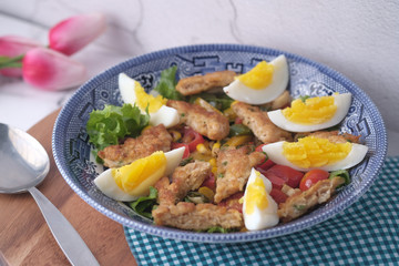 Homemade chicken nuggets with salad on plate