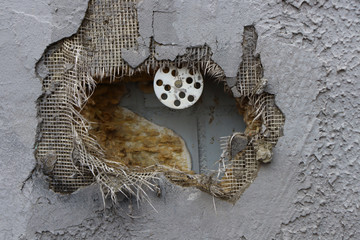 Fototapeta na wymiar Hole in the wall. Protruding insulation through plaster in the wall.