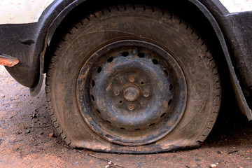 Fototapeta na wymiar Punched wheel of a car on asphalt. Flat tire machine
