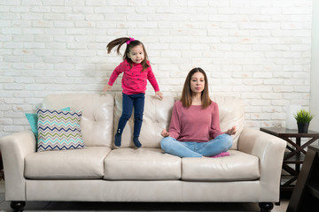 Mother trying to meditate with restless kid