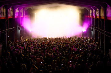 crowd in front of a vibrant stage at a concert festival. music show banner. people waiting for the...