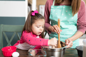 Cute little girl cooking with her mom