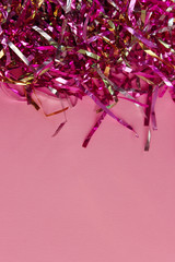 Blurry image of colorful sparkly ribbons on pink pastel trendy background. Festive backdrop for your projects.