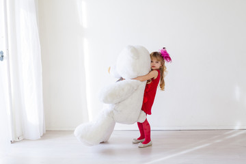 Little beautiful girl on holiday with white bear toy