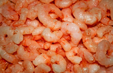 Background of peeled shrimp. Shrimp meat for sale. Texture. Seamless pattern, copy space.