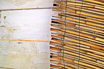 Holzwand und Bastmatte