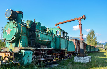 Old train locomotive green color on network of narrow-gauge railway in Carpathian village Kolochava, Transcarpathia, Ukraine 