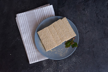 Healthy food. Crispbread with young leaves on a gray plate on a black background with a light cotton cloth. Diet and healthy eating. The concept of losing weight and a healthy lifestyle.