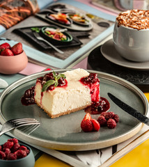 cheesecake slice garnished with berry jam and pieces