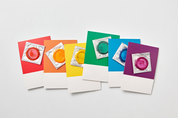 Gay pride flag colored cards with condoms.