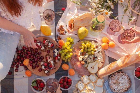 Unrecognizable women picking food at picnic