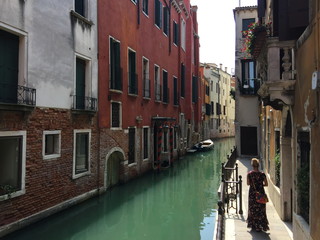 A young woman walking along the narrow, watery streets of old Venice