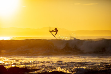 silhouette of a surfer doing an air at sunrise