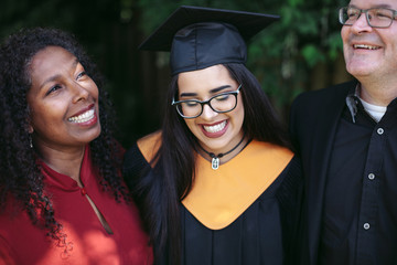 Parents and robe wearing daughter in the yard.