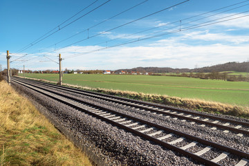 Railroad tracks through green meadow. German rail infrastructure