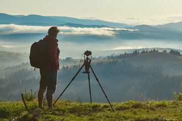 Photographer, Tripod Camera and Morning Panorama of the Carpathian Mountains