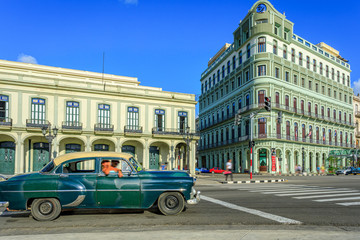 Havana Cuba Green vintage classic american car in a typical colorful street with sunny blue sky 