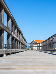 Fototapeta premium Composición pasarela con valla de madera en la playa junto a caseta