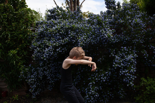 Dancing child in front of a Californian Lilac.