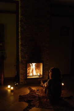 Woman basking by fireplace