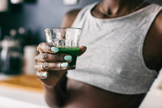 Black Woman Holding Glass of Green Juice