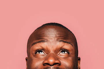 Happy young black man smiling and looking up