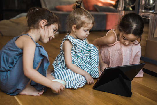 Three girls watching cartoons on a tablet