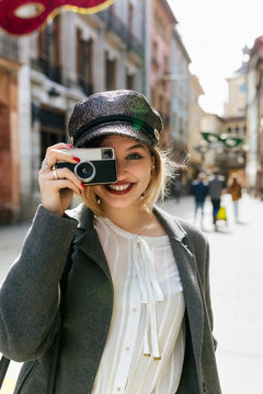 Blonde woman taking a picture on the street