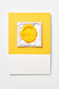 Yellow condom on a yellow card.