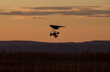 Fototapeta na wymiar beautiful sunset sky. hang-gliding. hang glider with a motor. hang glider at sunset