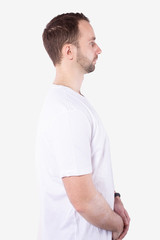 Obraz premium Man stands sideways and looks straight ahead. Arms folded. White background