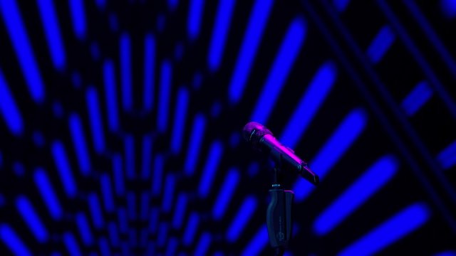 A microphone stands on a stand against a background of dynamic graphics, blue rays of light, a concert show, performance or karaoke. Background of vibrant color bokeh. 