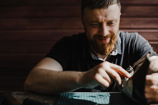 Face of a craftsman during a process of a creating handmade product. Man working in his workshop.