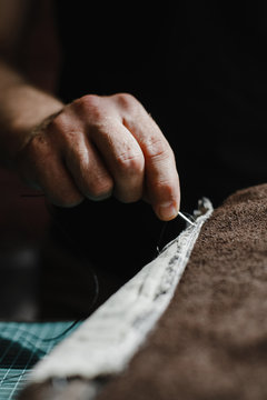 Close up of a leather and hands of a craftsman. Detail of a handmade process