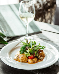 creamy mushroom dish topped with green salad with tomato