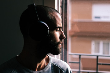 Handsome man wearing headphones at the window