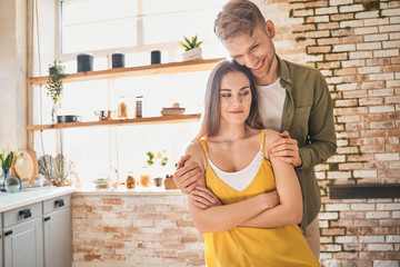 Positive delighted young couple being at home
