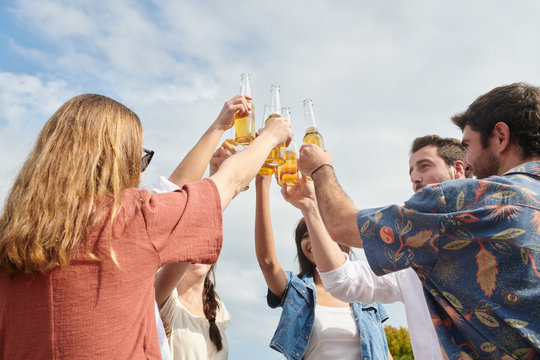 Friends with raised bottles in the air.